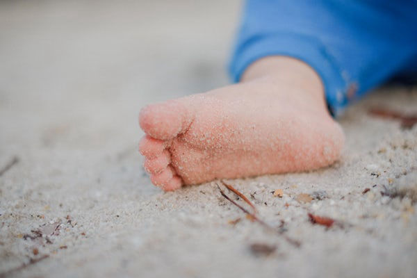 Baby feet on sand, representing velvet smooth and healthy feet